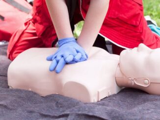 A person do CPR on a dummy.