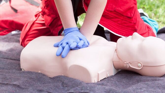 A person do CPR on a dummy.