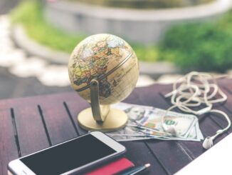 HealthyLivingLinks-globe on a table and phone, earphone, US dollars and a pen