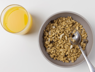 A bowl of cereals and a glass of juice