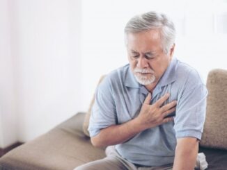 A senior man holding his heart bc of heart attack