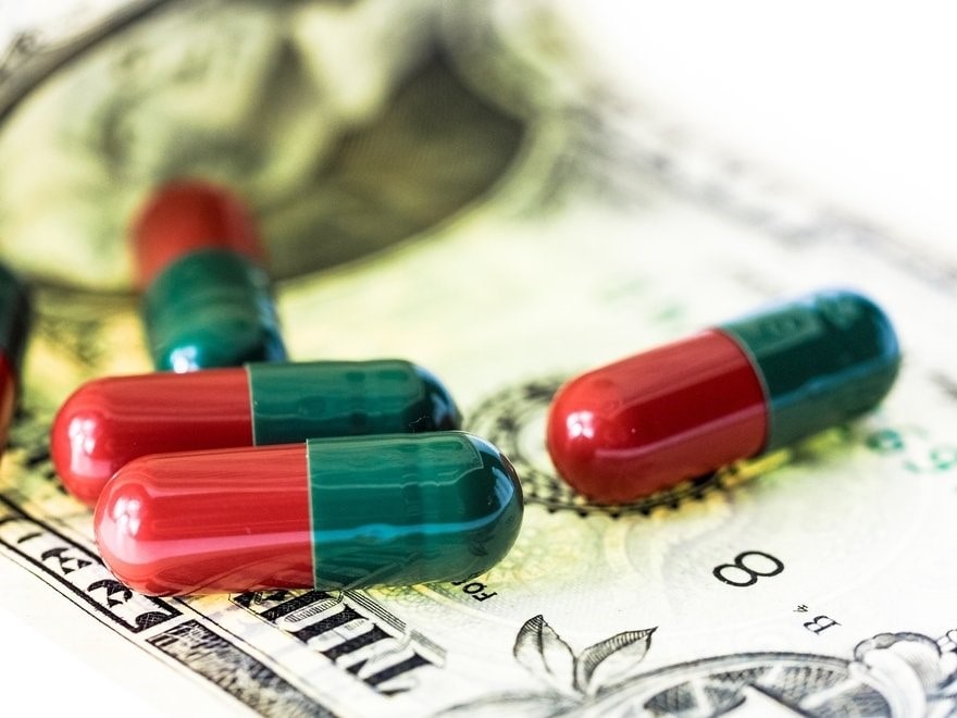 4 pills laying on a US dollar