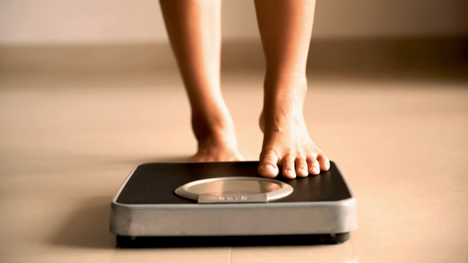 A person step on the weight scale