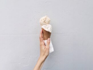 A person holding an ice cream in cone
