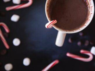 A cup of hot chocolate and some Christmas candy