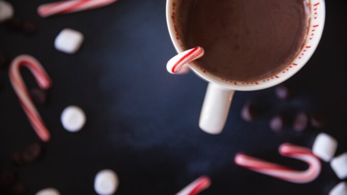 A cup of hot chocolate and some Christmas candy