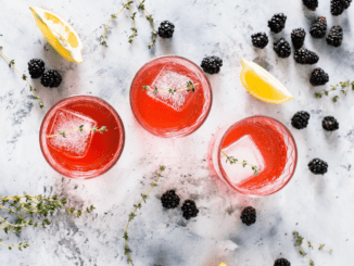 Three glasses of Mocktail with some lemon and blackberry.