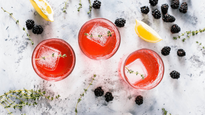 Three glasses of Mocktail with some lemon and blackberry.